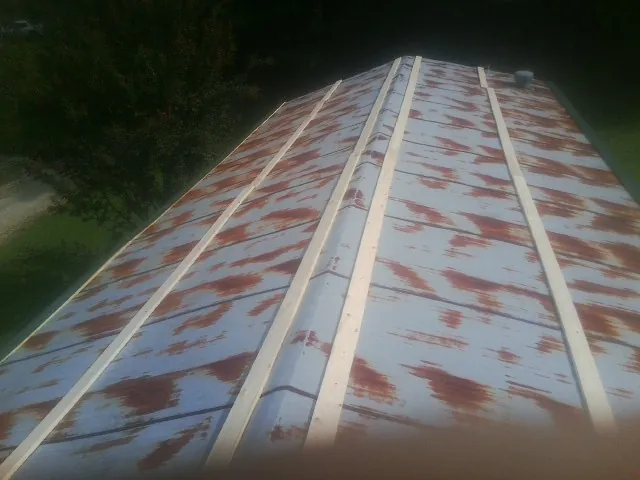 Rusted metal roof panels with new wood purlins before replacement — Storm Damage Roof Repair in Brookings by Roofing Brothers