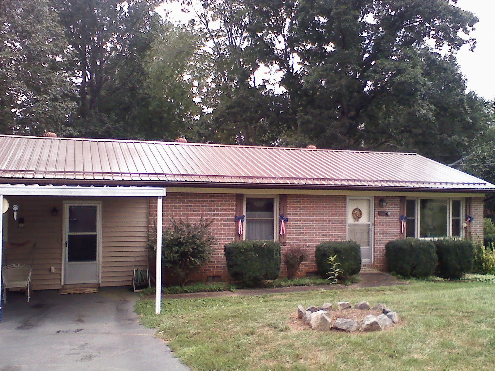 Bronze metal roof and carport on a brick ranch home — Roof Repair work by our crew in Brookings